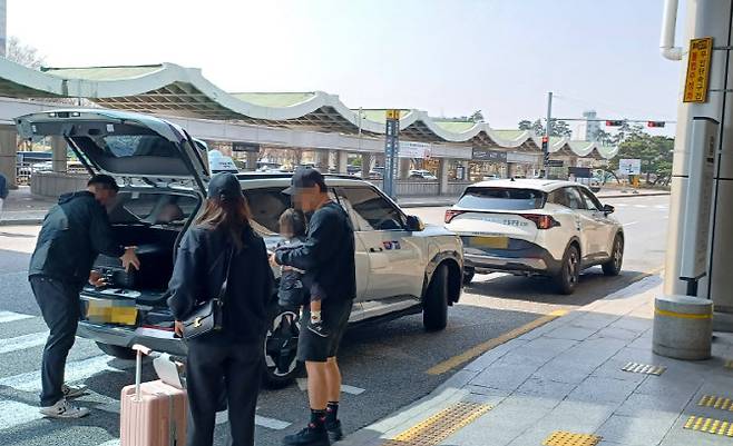 2일 오전 11시께 주정차 금지구역인 김포공항 국제선 앞 도로에서 택시 기사가 택시 트렁크에 손님의 짐을 싣고 있다. (사진 = 이종일 기자)