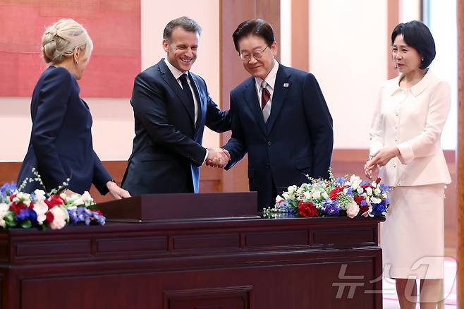이재명 대통령이 3일 청와대에서 정상회담에 앞서 에마뉘엘 마크롱 프랑스 대통령과 방명록을 보며 악수를 나누고 있다. 2026.4.3 ⓒ 뉴스1 허경 기자