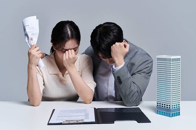 전세 계약 서류를 두고 고민하는 세입자들 모습. 보증금을 돌려받지 못했더라도 계약 당시 임대인의 기망 여부에 따라 전세사기와 단순 보증금 미반환으로 법적 판단이 달라진다. 게티이미지뱅크