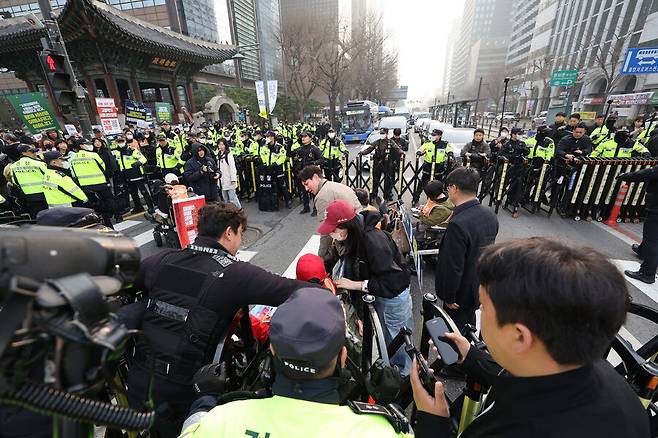 지난달 27일 서울 세종대로 사거리 버스 승강장 차로에서 전국장애인차별철폐연대(전장연) 회원들이 이동권 보장을 요구하며 시위를 하고 있다. 법원은 전장연의 지하철 시위에 대해 잇따라 유죄 선고를 내리고 있다. 연합뉴스