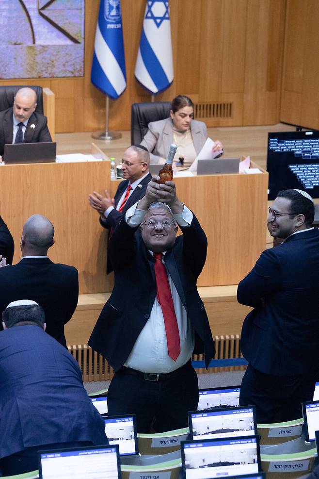 극우파인 이타마르 벤그비르 이스라엘 국가안보장관이 2026년 3월30일 의회(크네세트) 의사당에서 샴페인 병을 들어 올리며 환호하고 있다. REUTERS