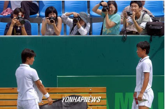 지난 2003년 대구 유니버시아드대회 테니스 여자복식에서 남.북대결을 관람하러온 시민들이 북한의 황은주,신선애 선수를 촬영하며 즐거워하는 모습. [연합뉴스 자료사진]