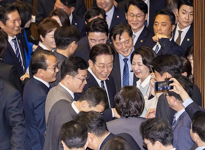 이재명 대통령이 지난 2일 국회에서 2026 추가경정예산안 시정연설을 마친 뒤 더불어민주당 의원들과 인사하며 본회의장을 떠나고 있다. [국회사진기자단, 연합뉴스]