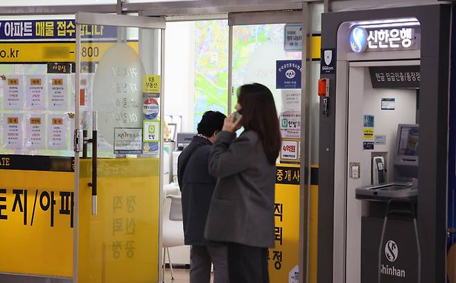 오는 17일부터 다주택자가 보유한 수도권·규제지역 아파트 담보대출의 만기연장이 원칙적으로 금지된다. 금융위원회는 1일 재정경제부, 국토교통부, 행정안전부 등 관계부처 합동으로 ‘2026년도 가계부채 관리 방안’을 발표했다. 사진은 이날 서울 강남구 한 부동산 중개업소와 은행 현금자동지급기 모습. [연합뉴스]