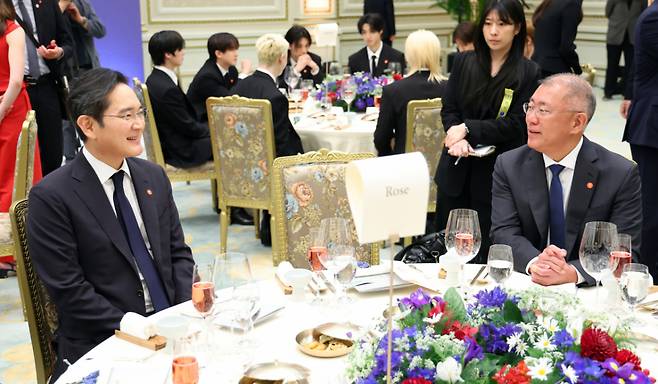 이재용 삼성전자 회장과 정의선 현대차그룹 회장이 3일 청와대 영빈관에서 열린 에마뉘엘 마크롱 프랑스 대통령 국빈 방한 환영 오찬에서 대화를 나누고 있다. 뒤로는 그룹 스트레이키즈 멤버들이 앉아 있다. /사진=뉴스1