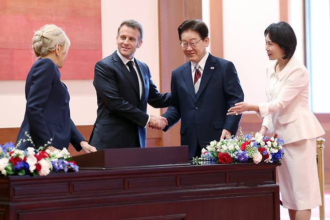 이재명 대통령이 3일 청와대에서 방명록을 작성한 에마뉘엘 마크롱 프랑스 대통령과 악수하고 있다. 연합뉴스