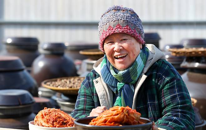 최근 '김치 책'을 출간한 고은정 음식연구가가 전북 남원 장독대에서 김치를 들고 활짝 웃고 있다. /김영근 기자