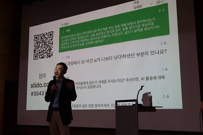 3일 저녁 서울 지하철 홍대입구역 인근 청년문화공간제이유(JU) 5층 니콜라오홀에서 열린 ‘김영민 vs 에이아이(AI) 에세이 첨삭 공개토크’에서 김영민 서울대 정치외교학부 교수가 청중들의 질문을 화면에 띄운 뒤 답하고 있다. 어크로스 출판사 제공