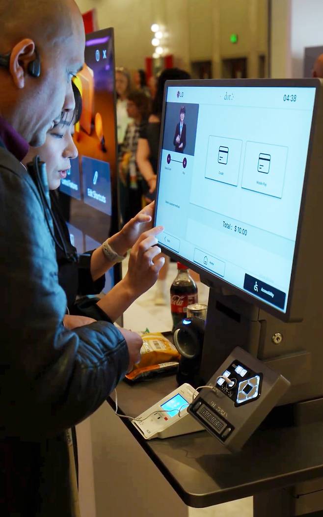 지난달 9일(현지시간) 미국 애너하임에서 열린 ‘CSUN AT 2026’에서 참가자가 수어 안내가 적용된 키오스크를 살펴보고 있다. LG전자 제공