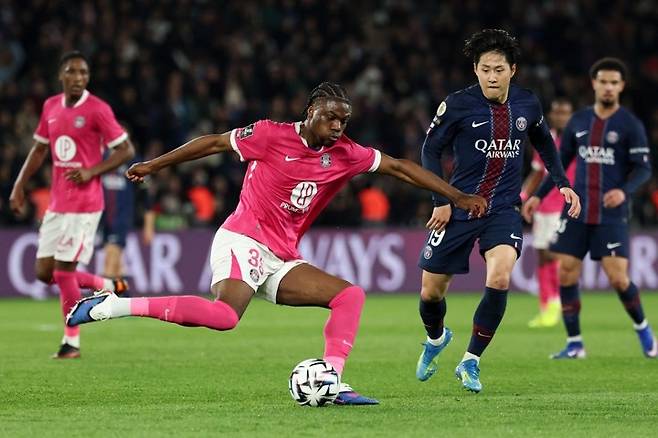 툴루즈의 프랑스 미드필더 세니 쿰바사(등번호 35번, 왼쪽)가 파리 생제르맹의 한국인 미드필더 이강인(등번호 19번)을 제치고 슛을 날리고 있다. AFP연합뉴스