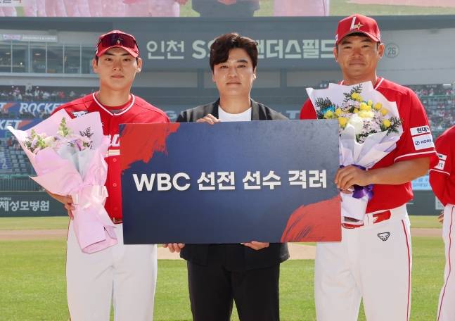 SSG 랜더스 조병현(왼쪽)과 노경은(오른쪽)이 지난달 28일 홈 개막전에서 열린 WBC 선전 격려식에서 추신수 구단주 보좌역 겸 육성총괄로부터 꽃다발을 건네 받고 기념촬영을 하고 있다. /사진=강영조 선임기자