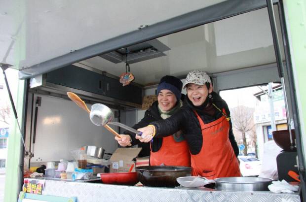 ‘십시일반 음식연대 밥묵차’에서 포즈를 취한 유희.(오른쪽) <소금꽃 제공>