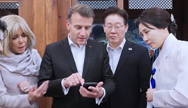 2일 청와대 상춘재에서 진행된 이재명 대통령과의 친교 만찬장에서 블랙핑크 공연 영상을 찾아 보여주고 있는 에마뉘엘 마크롱 프랑스 대통령. 청와대 누리집 갈무리