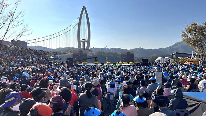 전북 임실군 운암면 옥정호 붕어섬 출렁다리를 무대로 지난해 봄 열린 ‘옥정호 벚꽃축제’ 모습. 올해도 오는 11~12일 붕어섬 일대 3만여 본의 봄꽃과 함께 가요제, 공연 등이 결합된 프로그램으로 축제를 연다. 임실군 제공