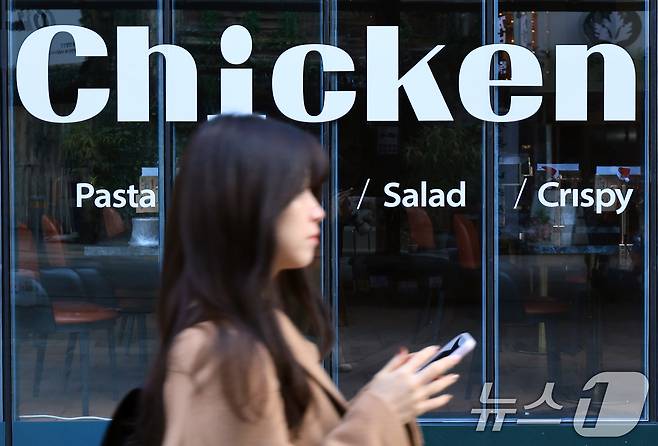 서울 시내의 한 치킨매장 앞으로 시민이 지나가고 있다. 2025.12.15 ⓒ 뉴스1 이호윤 기자