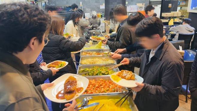 지난 1일 오후 서울 구로구의 한 호프집에서 직장인들이 점심 8000원 무한리필 뷔페를 이용하기 위해 음식을 담고 있다. 박호수 기자