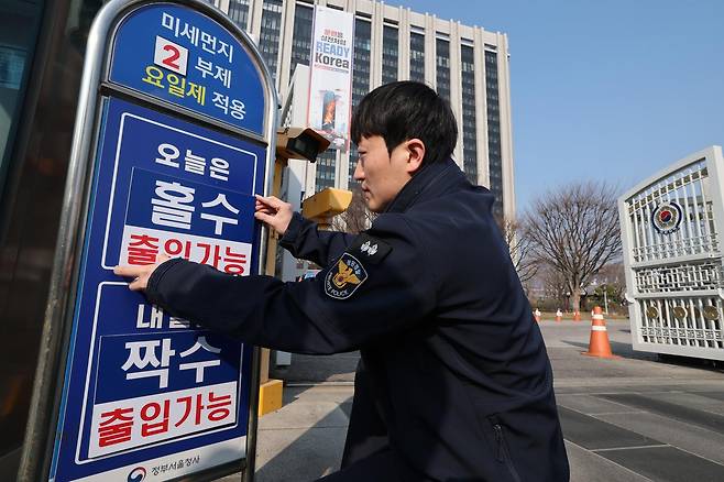 서울 종로구 정부서울청사에서 관계자가 차량 2부제 실시 안내판을 설치하고 있다. 2026.3.17. 뉴스1