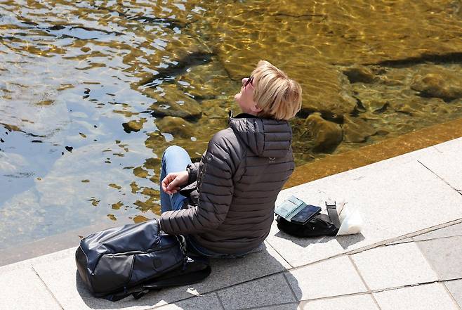 서울의 낮 최고기온이 14도를 기록하는 등 포근한 날씨를 보인 12일 오후 서울 종로구 청계천을 찾은 외국인 관광객이 휴식을 취하고 있다. 2026.3.12/뉴스1