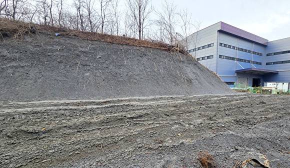 용인특례시 처인구 원삼면 맹리 659-19번지 일대 회색 흙이 쌓인 산 옆으로 물류창고가 보인다. [사진=정재수 기자]