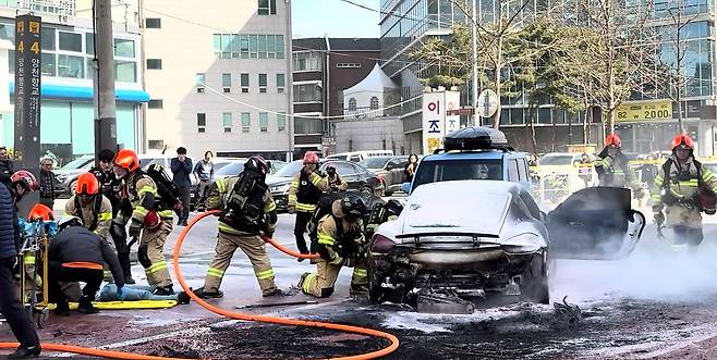 서울 강서구 가양동에서 포르쉐 승용차가 중앙선을 넘어 차량 1대 충돌 후 갑자기 가속페달을 밟아 다른 차량 2대를 연속으로 정면 충돌하는 사고가 발생, 소방대원들이 차량에서 난 화재를 진압하고 있다. 뉴스1