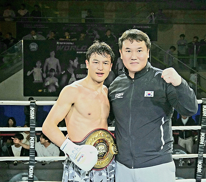 세계복싱협회 라이트급 아시아 챔피언 최시로가 2026년 4월 경기도 남양주체육문화센터 특설 링에서 타이틀 2차 방어 성공 기념 촬영을 하고 있다. 오른쪽은 FW1 최완일 대표. 사진=한국복싱커미션 KBM
