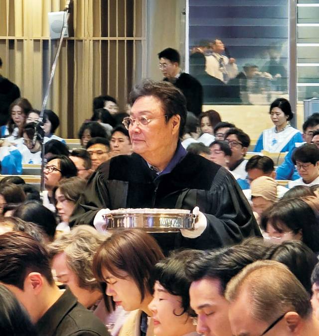 교회 장로인 남진이 올해 봄 성찬식에서 신도들에게 떡을 나눠주는 모습. 새에덴교회 제공