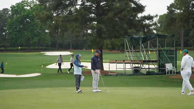 저스틴 로즈(오른쪽 두 번째)가 5일(현지 시간) 미국 조지아주 오거스타 내셔널GC 연습 그린에서 비옷을 입고 퍼트 점검을 하고 있다. 오거스타=양준호 기자