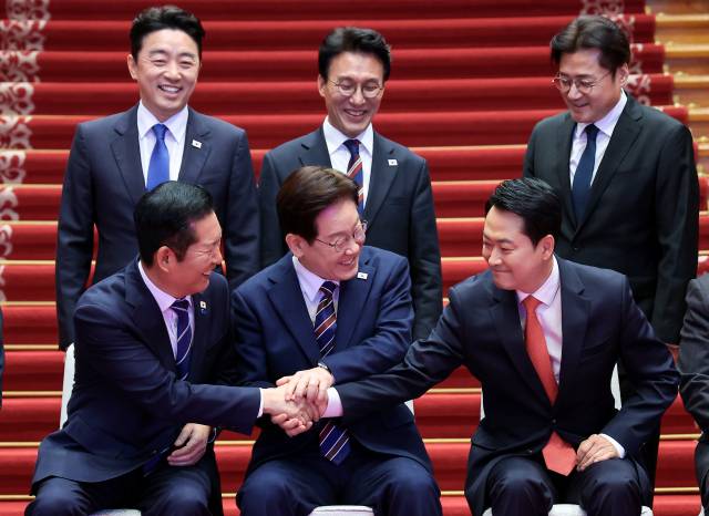 이재명 대통령이 7일 청와대에서 열린 여·야·정 민생경제 협의체 회담에 앞서 정청래 더불어민주당 대표와 장동혁 국민의힘 대표의 손을 맞잡게 하고 있다. 연합뉴스