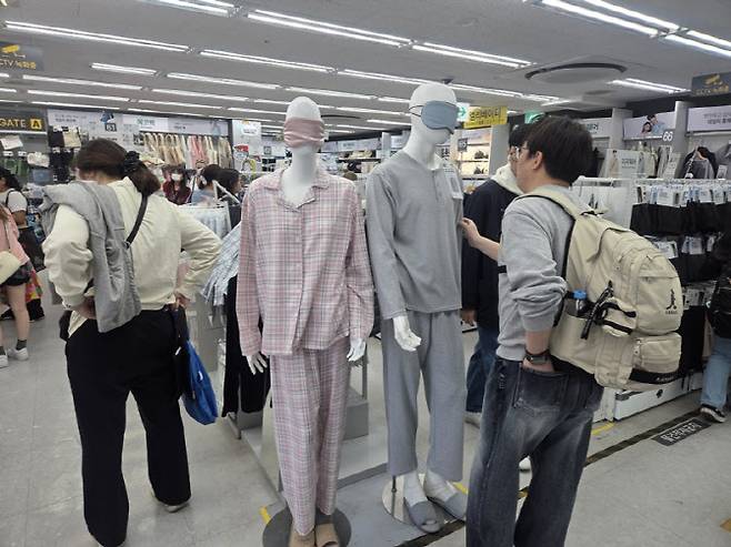 파자마 세트를 입은 마네킹 앞으로 손님들이 오가고 있다. 파자마 가격은 5000원이다. (사진=한전진 기자)