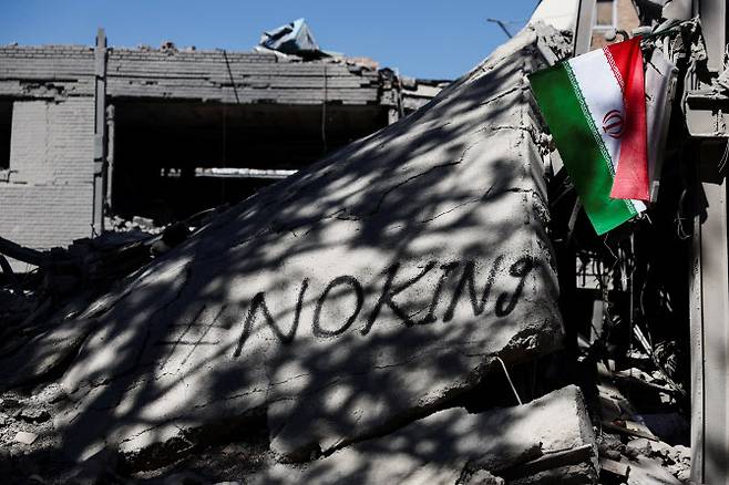 이란 테헤란 샤리프 공과대학교 건물이 공습으로 피해를 입은 가운데, 잔해 사이에 이란 국기가 걸려 있다.(사진=AFP)