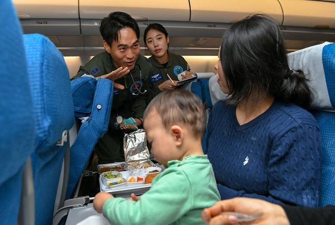 지난달 15일 '사막의 빛' 작전 중 공군 수송기(KC-330)에 탑승한 군의관이 감기 증세가 있는 어린아이를 살피고 있다. /국방부