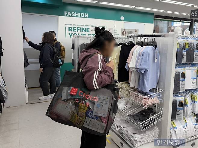 8일 방문한 서울 중구 다이소 명동역점 12층에서 외국인 관광객이 의류를 구경하고 있다. / 사진=이수 기자