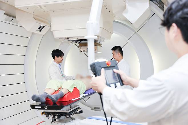유정일(맨 왼쪽) 삼성서울병원 방사선종양학과 교수가 양성자 치료 직전, 간암 환자에게 치료 방식을 설명하고 있다. /사진=삼성서울병원