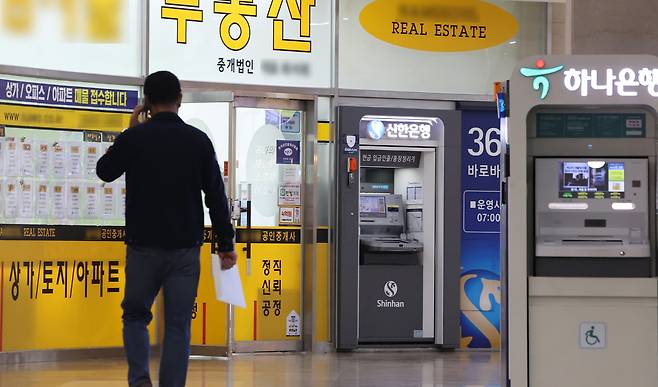 정부가 ‘비거주 1주택’의 세 낀 매물도 매도할 수 있도록 방안을 검토중인 가운데 시장에선 정책 실효성을 의심하는 목소리가 높다. 사진은 이날 서울 한 부동산 중개업소와 은행 현금자동지급기 모습. [연합]