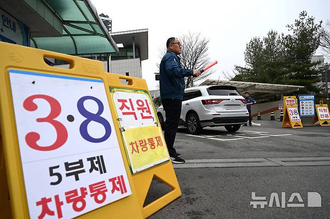 [광주=뉴시스] 이현행 기자 = 중동전쟁 여파에 따른 에너지 절약 정책으로 차량 5부제가 시행된 첫날인 25일 오전 광주  서구청에서 한 차량이 청원경찰의 안내를 받고 진입하고 있다. 2026.03.25. lhh@newsis.com