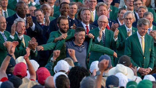 지난해 마스터스에서 스코티 셰플러가 로리 매킬로이에게 그린 재킷을 입혀주고 있다.