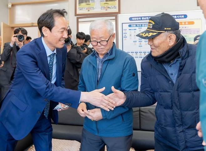 더불어민주당 강원지사 후보로 단수 공천된 우상호(왼쪽) 전 청와대 정무수석이 지난 7일 강원 강릉시 보훈단체 임원진을 만나 악수하고 있다.  우상호 페이스북 캡처