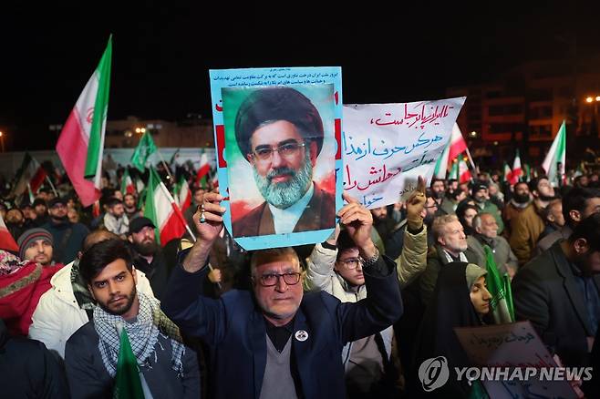 사망한 이란 전 최고지도자 하메네이 초상화를 들고 시위에 참여한 이란 친정부 시위대 [EPA=연합뉴스. 재판매 및 DB 금지]