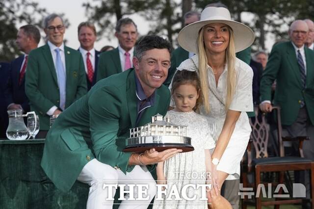 로리 맥길로이가 지난해 우승해 커리어 그랜드슬램을 달성한 뒤 그린 재킷을 입고 우승 트로피를 들며 가족들과 함께 기뻐하고 있다../AP.뉴시스