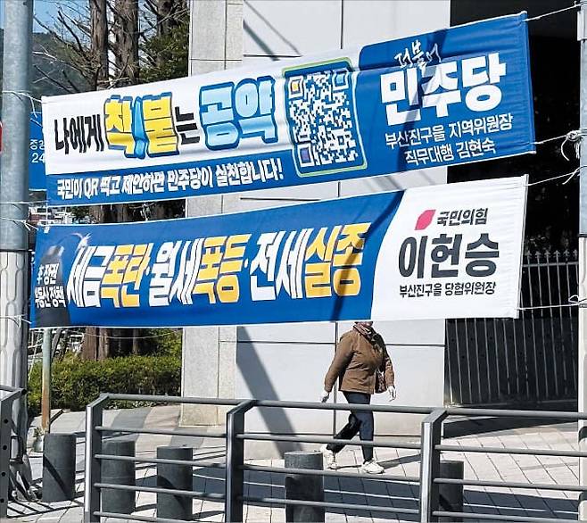 8일 부산 부산진구 동천대로 건널목 부근에 파란색 더불어민주당 현수막(위)과 파란색 국민의힘 현수막(아래)이 나란히 붙어 있다. /연합뉴스