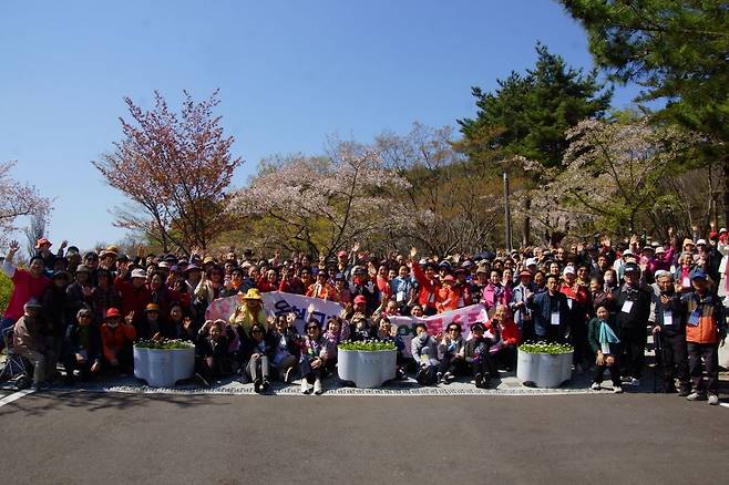 부산 온천교회 시니어 어르신들이 8일 수요예배를 드린 뒤 경주로 봄 소풍을 다녀왔다. 450여명의 어르신들과 자원봉사자들이 경주 벚꽃단지에서 단체로 기념촬영을 하고 있다.