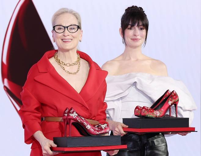 영화 ‘악마는 프라다를 입는다2’의 주연배우 메릴 스트리프(왼쪽)와 앤 해서웨이가 8일 서울 종로구 포시즌스호텔에서 열린 방한 기자간담회에서 ‘꽃신’을 재해석한 하이힐을 선물받은 뒤 기념촬영을 하고 있다.  연합뉴스