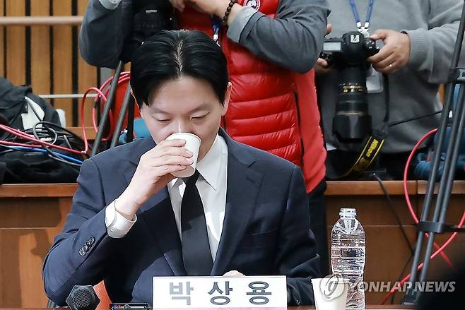 목 축이는 박상용 검사 (서울=연합뉴스) 신현우 기자 = 쌍방울 대북송금 사건을 수사했던 박상용 검사가 7일 국회에서 윤석열 정권 정치검찰 조작기소 의혹 사건 진상규명 국정조사특별위원회 국민의힘 위원들이 연 '민주당의 공소취소·재판조작 진상규명 청문회'에 참석해 목을 축이고 있다. 2026.4.7 nowwego@yna.co.kr
