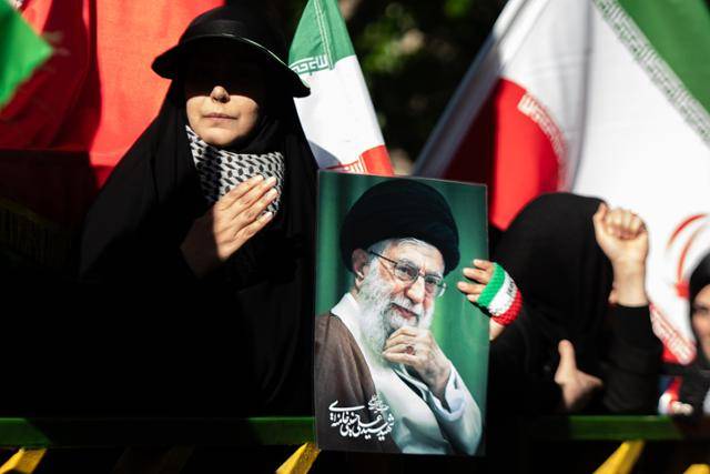 전쟁 첫날 숨진 전 최고지도자 아야톨라 세예드 알리 하메네이의 사망 40일째를 맞아 이란 시민들이 9일 테헤란 거리에서 그의 사진을 들고 추모하고 있다. 테헤란=UPI 연합뉴스