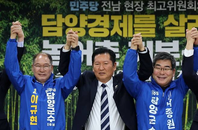 더불어민주당 정청래 대표와 박종원, 이규현 담양군수 예비후보가 10일 전남 담양농협 본점에서 열린 현장 최고위원회의를 마친 뒤 손을 번쩍 들어 올리고 있다. 연합뉴스