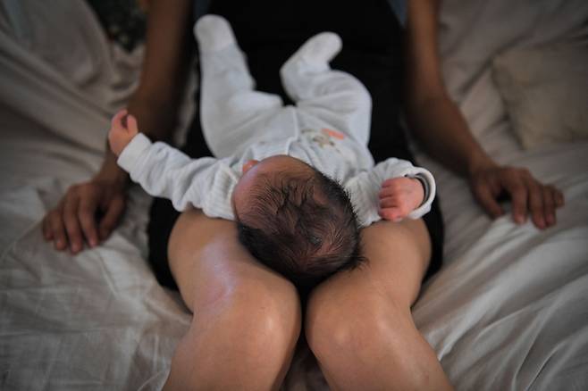한 여성이 자신의 아이를 무릎 위에 올려놓은 사진. AFP연합뉴스