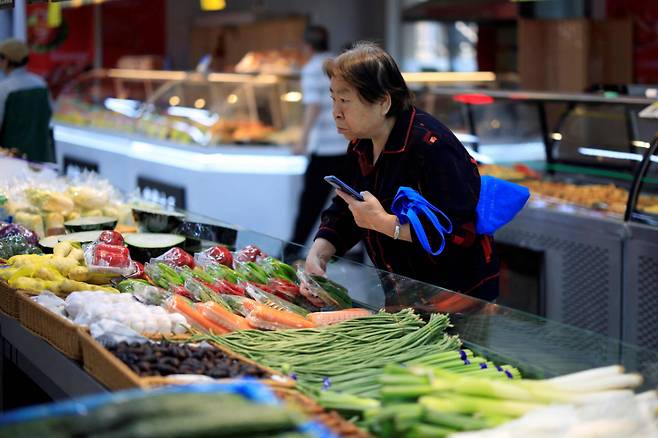 (선양 AFP=뉴스1)  = 2025년 6월9일 중국 선양의 한 슈퍼에서 한 여성이 식료품을 고르고 있다. 2025.06.09.