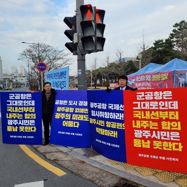 광주공항 국제선 부활 시민회의가 민간공항 선이전에 반대하는 손팻말을 들고 있다.