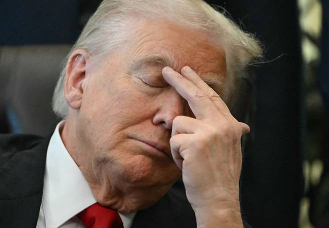 도널드 트럼프 미국 대통령이 지난해 11월 6일(현지시간) 워싱턴 백악관 집무실에서 열린 행사 도중 눈을 감은 채 손으로 이마를 짚고 있다. 2025.11.6 워싱턴 AFP 연합뉴스