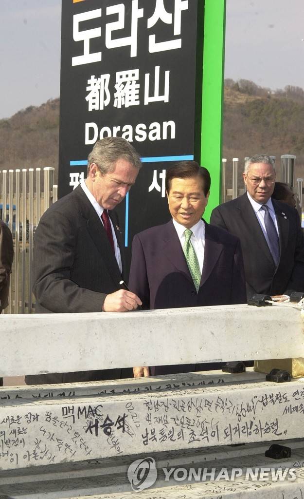 도라산역의 한미 정상 (서울=연합뉴스) 2002년 2월 20일 오후 경의선종착역인 도라산역을 방문한 부시미대통령이 침목에 서명하는 것을 김대중대통령이 지켜보고 있다. 2009.8.18 << 연합뉴스 자료사진 >>